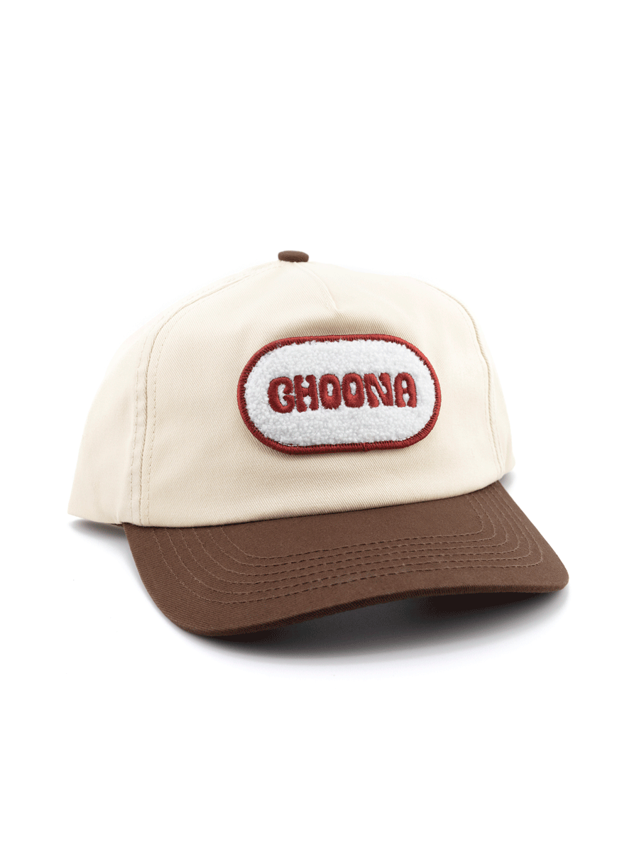 The Choona Fly Patch Snapback is a beige unstructured cotton twill cap with a brown brim, white oval fly patch outlined in red, and bold red CHOONA embroidery.