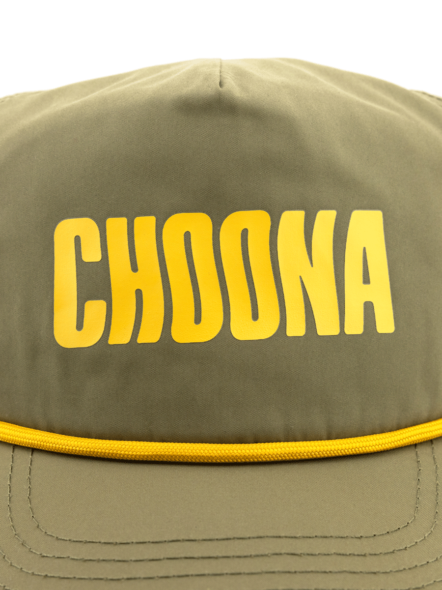 A close-up of the Choona Wavy Snapback in olive green, featuring bold yellow CHOONA lettering on the front and crafted with quick-drying fabric for coastal adventures.