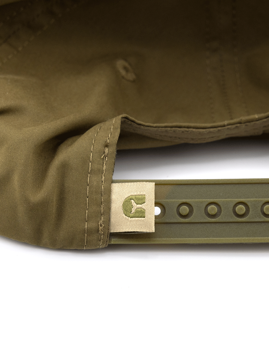 Close-up of the adjustable snapback strap on Choona’s Dune Lake Snapback in olive green, featuring stitching details and a small beige tag with a dark green bear logo. Ideal for sunny days, this cap offers both comfort and style.