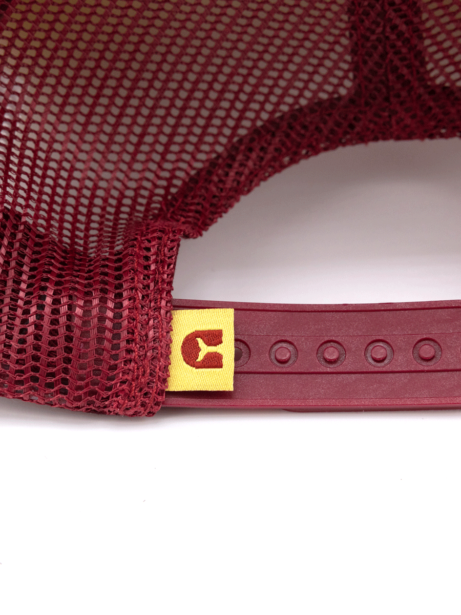 Close-up of the back of the Choona Redfish Foam Snapback, a maroon mesh trucker hat featuring an adjustable foam snapback, modern fit, and a small yellow tag with a redfish silhouette—blending throwback style with contemporary design.