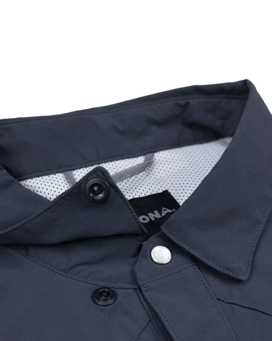 Close-up of the collar and upper buttons of the Choona Panhandle Pearl Snap, showing its white snap button, black inner tag, and mesh-like lining—ideal for nailing that coastal cowboy style from the Florida Panhandle.