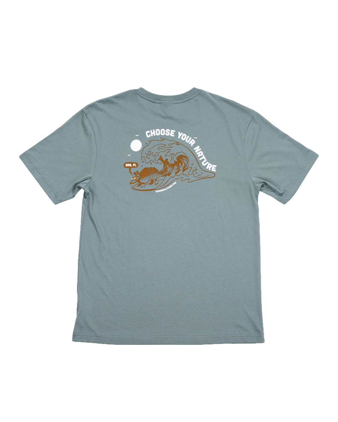 The Choona Armachillo Graphic Tee is a light blue retro surf shirt made from USA-grown cotton, featuring a cartoon tiger surfing and "CHOOSE YOUR WAVE" above the graphic.
