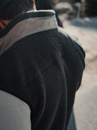 Close-up of a person wearing the Choona Pt. Washington Sherpa Vest with a light beige collar. The photo is taken outdoors in natural daylight, featuring a softly blurred background.