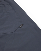 Close-up of the Choona Drifter Pant’s dark blue four-way stretch fabric, showing a stitched pocket and small black SHOWA tag on the side, set against a white background.