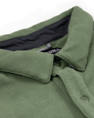 Close-up of the Choona Skipper Shacket: a green fleece jacket featuring a collar, snap buttons, partial black inner lining, and visible label—perfect for cold weather.