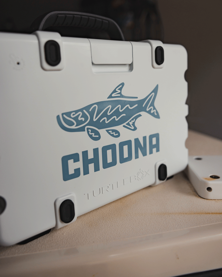 A white hard plastic case with black latches displays a blue tarpon decal and the bold Choona name, plus a subtle brand logo below—complete with an adventure-inspired sticker that encourages you to Choose Your Nature.