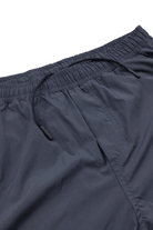 Close-up of Choona Shore Short in dark navy blue with an elastic waistband, black drawstring, wicking technology, and side pockets—ideal for coastal adventures. Displayed on a white background.