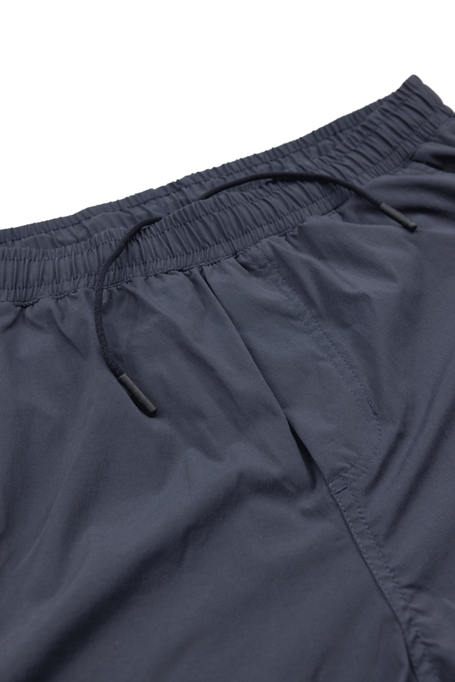 Close-up of Choona Shore Short in dark navy blue with an elastic waistband, black drawstring, wicking technology, and side pockets—ideal for coastal adventures. Displayed on a white background.