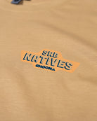 A close-up of the Choona SRB Natives Graphic Tee, a tan Pima Cotton shirt featuring SRB NATIVES CHOONA in bold blue letters atop an orange background—ideal for Santa Rosa Beach style.