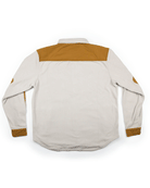 A long-sleeve light beige Choona Skipper Shacket, made from recycled polyester with brown shoulder, elbow, and cuff patches, is shown flat with the back up on a white background—a versatile cold-weather piece.