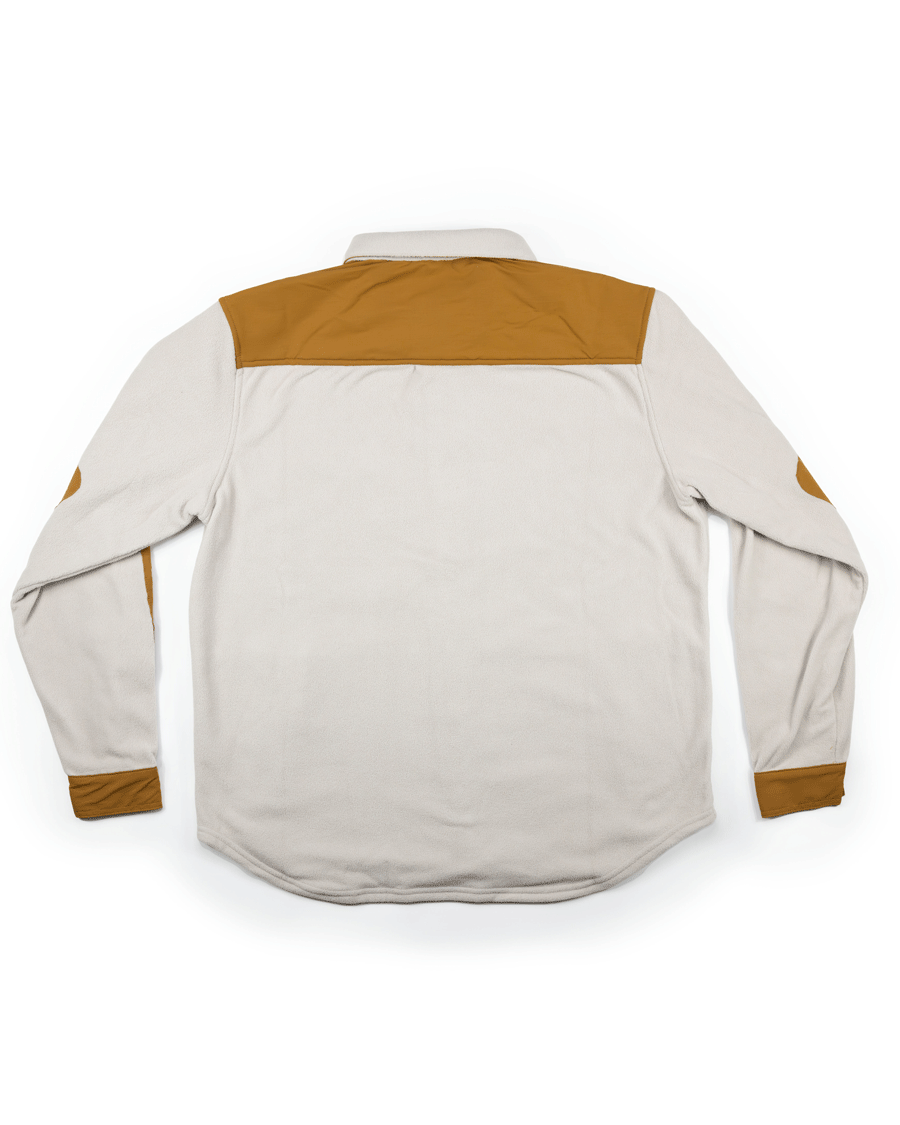 A long-sleeve light beige Choona Skipper Shacket, made from recycled polyester with brown shoulder, elbow, and cuff patches, is shown flat with the back up on a white background—a versatile cold-weather piece.