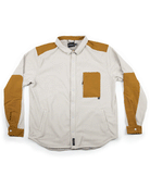 The Choona Skipper Shacket is a long-sleeve, off-white button-up with tan patches on the shoulders, elbows, cuffs, and chest pocket. Made from recycled polyester, it features a collar and snap front, ideal for cold weather.