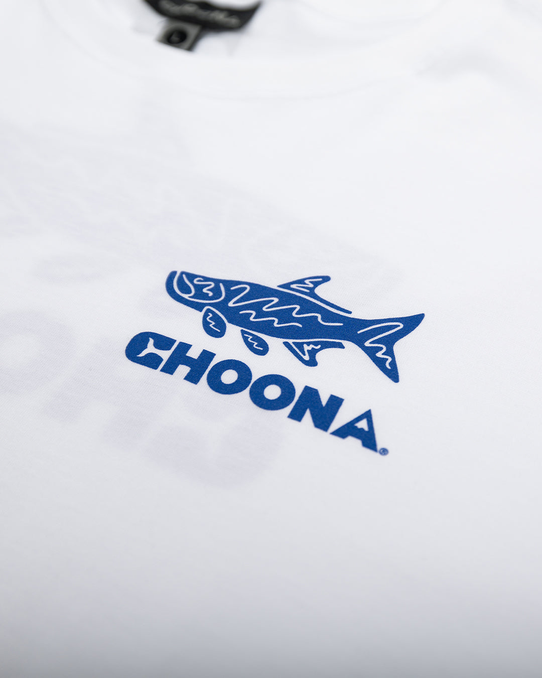 A close-up of the Tarpon Graphic Tee by Choona, showing a blue stylized fish above "CHOONA" in bold blue letters. Perfect for fishing fans, with the shirt tag partly visible at the top.