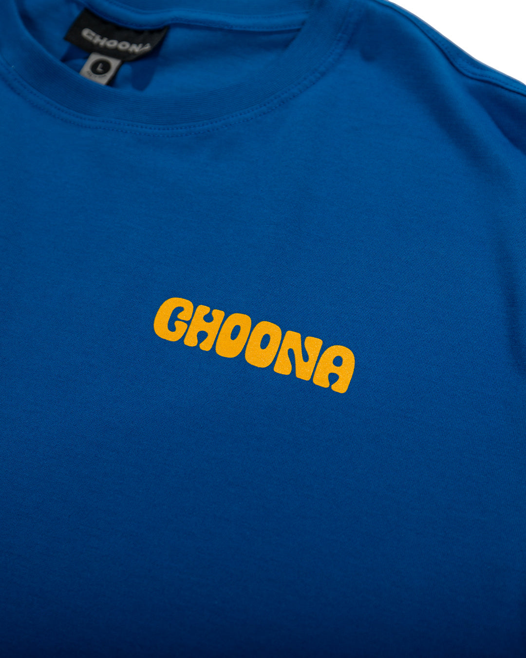 The Choona Swell Dweller Graphic Tee features bold yellow "CHOONA" lettering on a blue shirt, ideal for fans of surfer style and classic surfboard fashion.