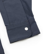 A close-up of a dark blue Choona Panhandle Pearl Snap cuff with a silver button and detailed stitching on white—ideal for adding coastal cowboy flair to your Florida Panhandle wardrobe.