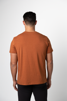 A man with short dark hair wears a Choona Panhandle Pocket Tee made from a sustainable Lyocell blend and black pants, standing with his back to the camera against a plain white background.